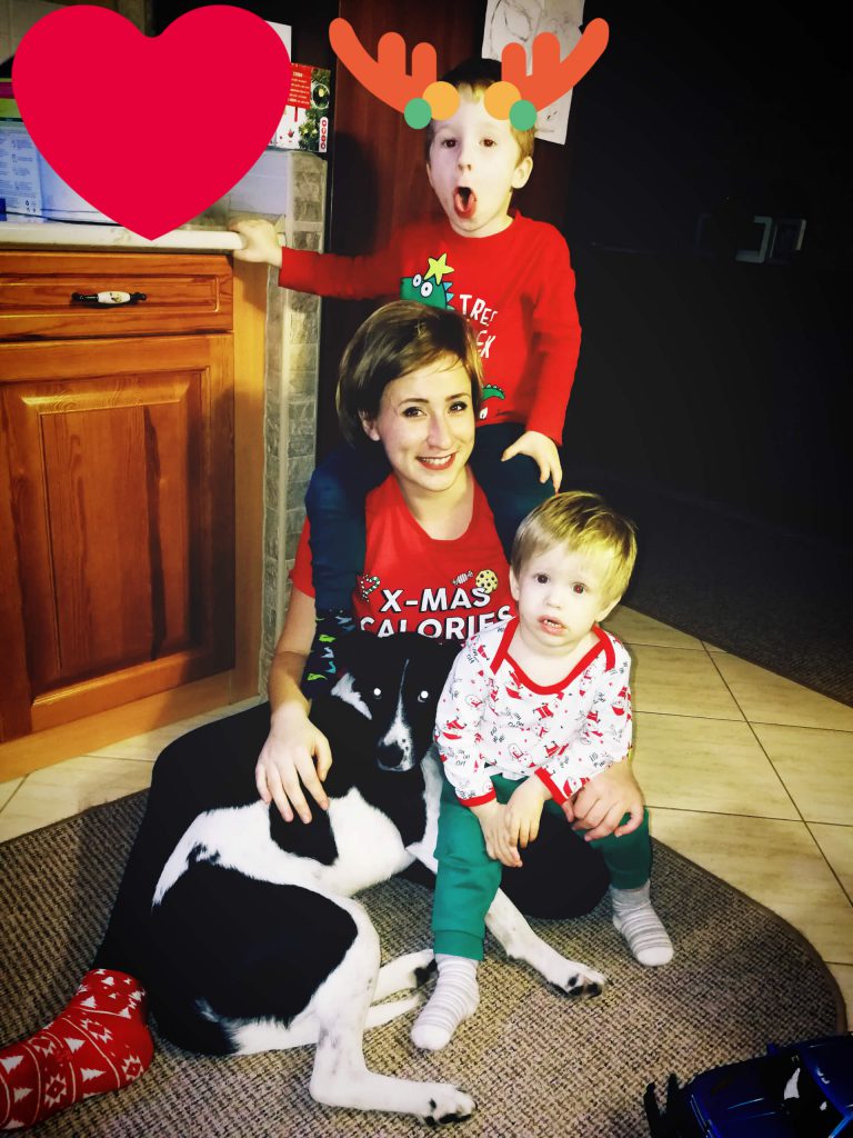 LucaKutya otthon a családdal a konyhában fekszik a gazdájával és a két kisfiával.